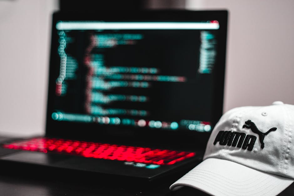 A person holds a rectangular sticker with rounded corners featuring the HTML5 logo, which includes the word 'HTML' in black uppercase letters at the top and a prominent red shield-shaped emblem with t